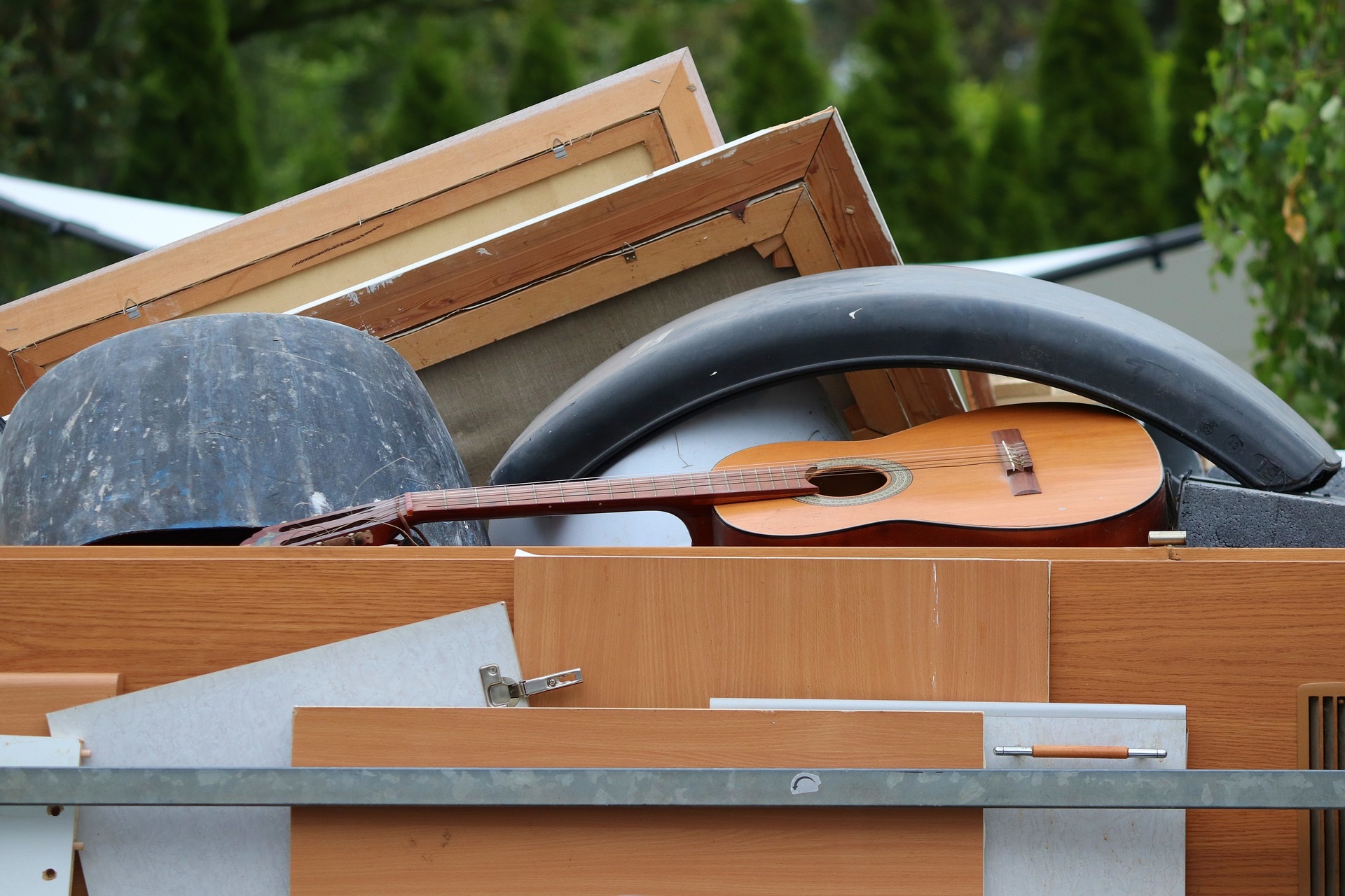 Bulky items loaded for collection, including picture frames, cabinet doors and an acoustic guitar