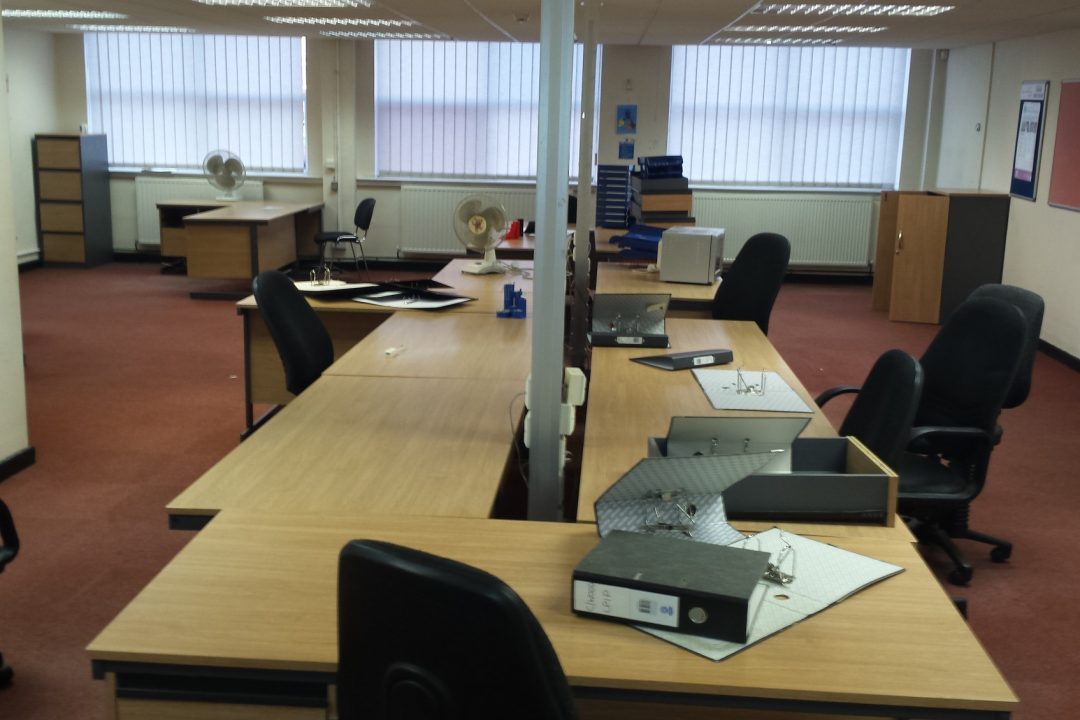 An office part-way through clearance, with desks, chairs and ring binders left in place